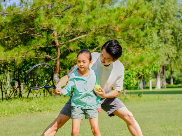 Feliz pai e filha estão jogando tênis no parque — Fotografia de Stock