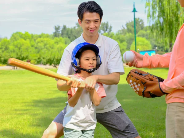 Familia feliz de tres jugando béisbol en el parque —  Fotos de Stock