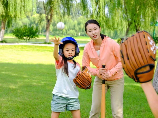 Família feliz de três jogando beisebol no parque — Fotografia de Stock