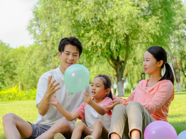 Família feliz de três no parque — Fotografia de Stock