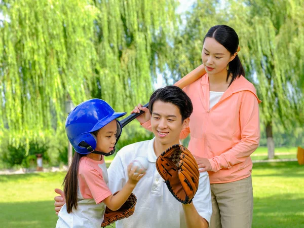 Счастливая семья из трех человек играет в бейсбол в парке — стоковое фото