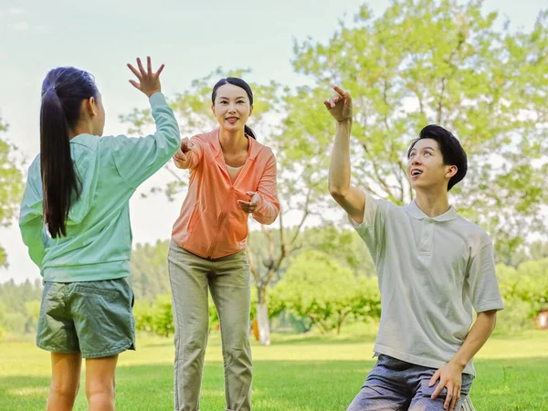 Família feliz de três jogando basquete no parque — Fotografia de Stock