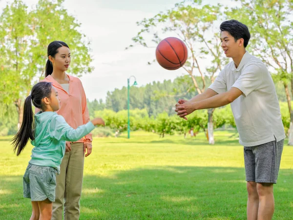 Família feliz de três jogando basquete no parque — Fotografia de Stock