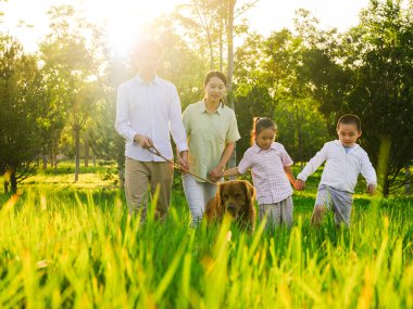 Parkta dört köpekli mutlu bir aile.
