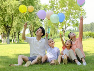 Parkta dört kişilik mutlu bir aile.