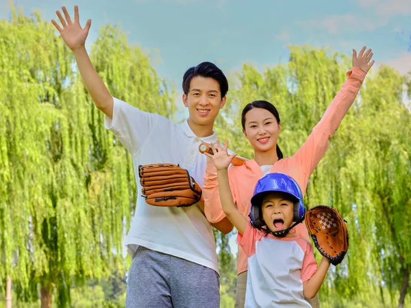 Gelukkig gezin van drie honkbal spelend in het park — Stockfoto