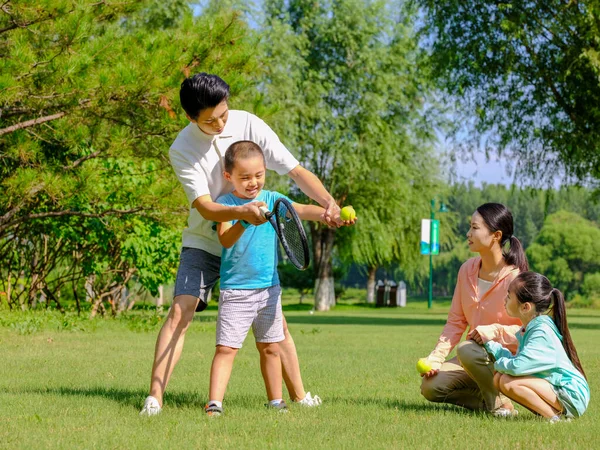 공원에서 네 명의 테니스를 하는 행복 한 가족 — 스톡 사진