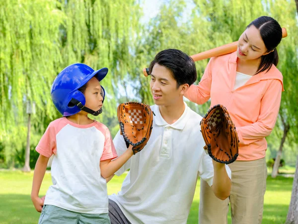 Família feliz de três jogando beisebol no parque — Fotografia de Stock