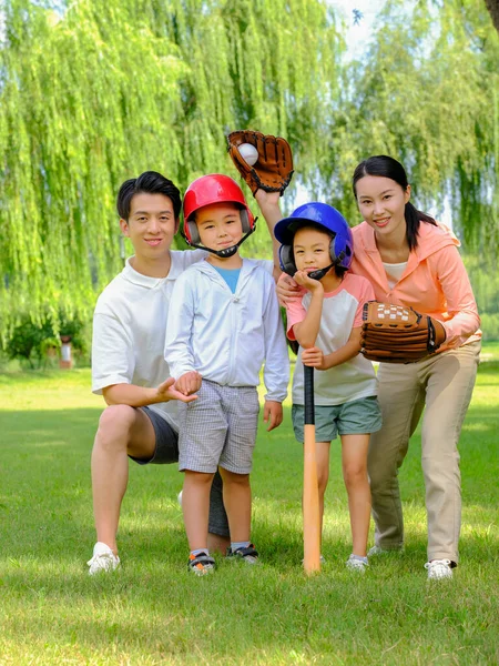 Gelukkige familie van vier spelen honkbal in het park — Stockfoto