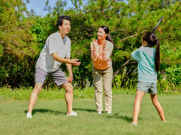 Happy family of three playing tennis in the park — Stock Photo, Image