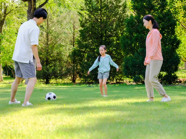 Família feliz de três jogando futebol no parque — Fotografia de Stock