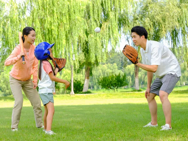 Família feliz de três jogando beisebol no parque — Fotografia de Stock