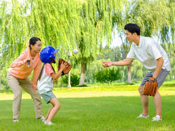 Parkta beyzbol oynayan üç kişilik mutlu bir aile. — Stok fotoğraf