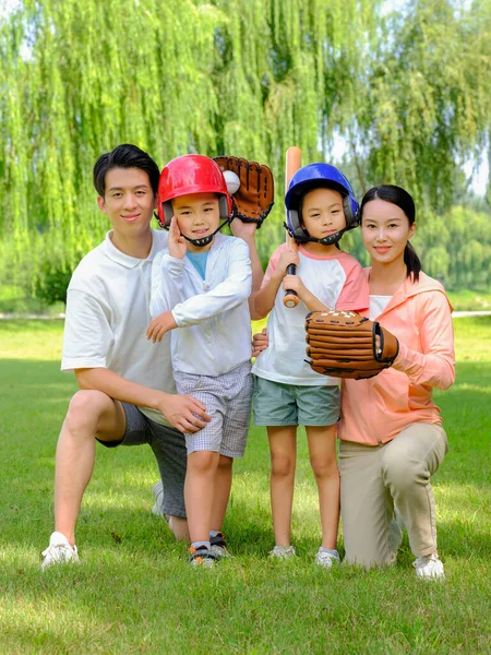 Bonne famille de quatre personnes jouant au baseball dans le parc — Photo