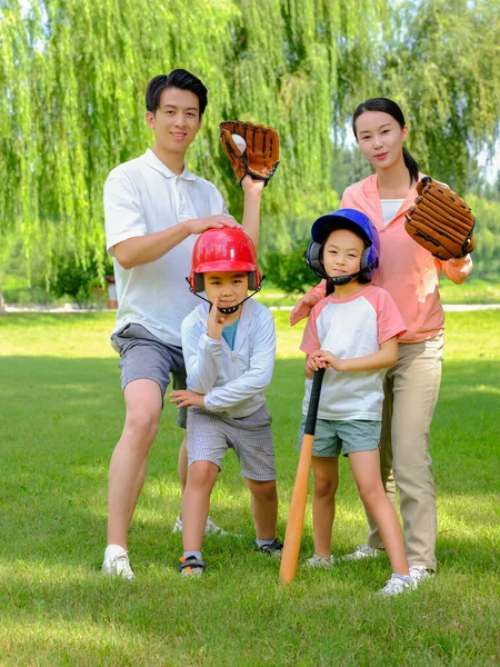 Famiglia felice di quattro che giocano a baseball nel parco — Foto Stock