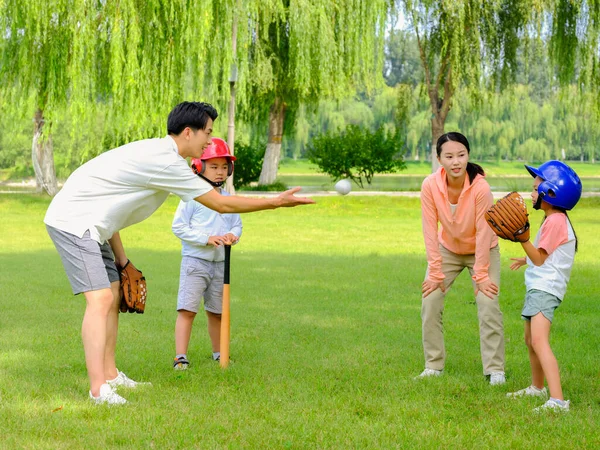 Ευτυχισμένη οικογένεια τεσσάρων παιδιών που παίζουν μπέιζμπολ στο πάρκο. — Φωτογραφία Αρχείου