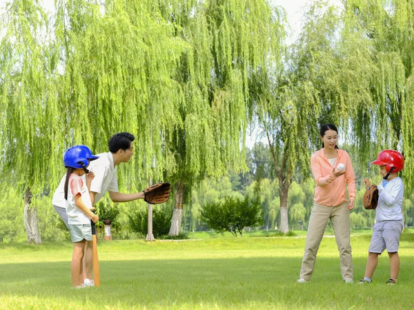 一家四口快乐地在公园里打棒球 — 图库照片