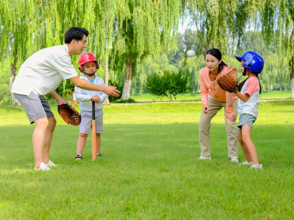 Bonne famille de quatre personnes jouant au baseball dans le parc — Photo