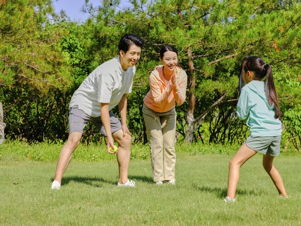 Familia feliz de tres jugando al tenis en el parque —  Fotos de Stock