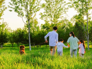 Parkta dört köpekli mutlu bir aile.