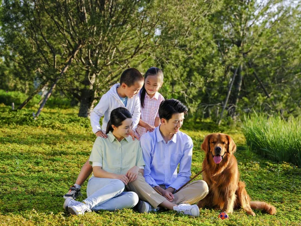 Família feliz de quatro e cão de estimação no parque — Fotografia de Stock