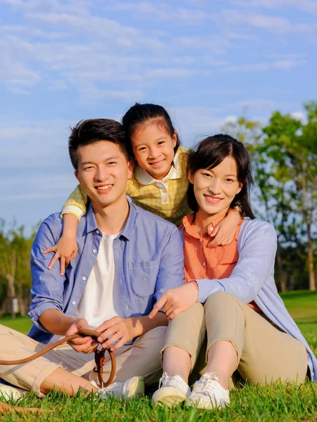 Счастливая семья из трех человек в парке — стоковое фото