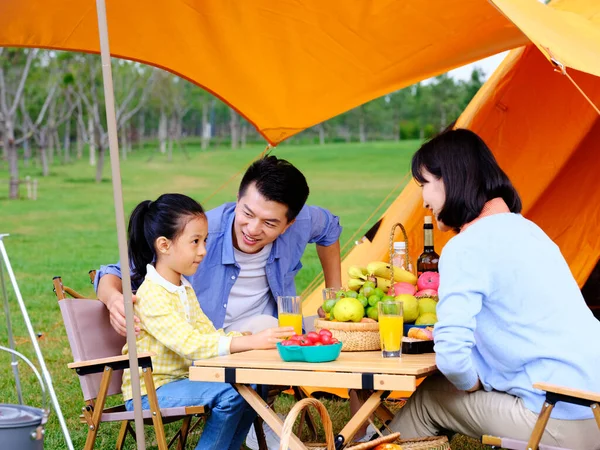 Uma família feliz de três acampar ao ar livre Imagem De Stock