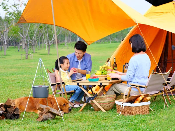 Família feliz de três e cão acampar fora — Fotografia de Stock