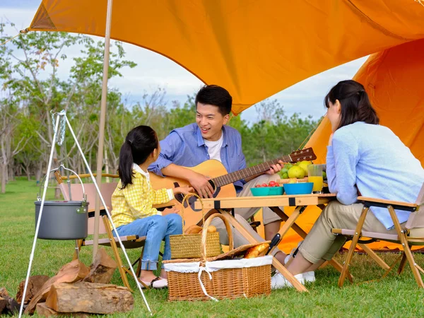 Happy family of three camping outdoors