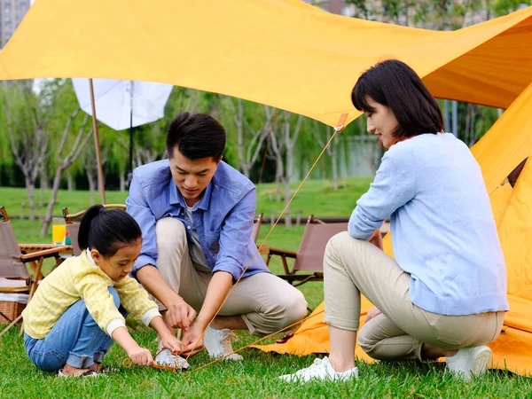 Счастливая семья из трех человек установила палатки на открытом воздухе — стоковое фото