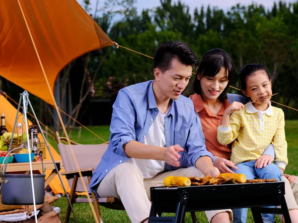 Una famiglia felice di tre barbecue nel parco — Foto Stock