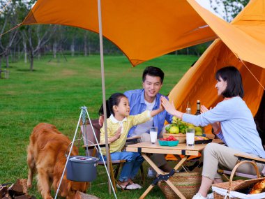 Üç kişilik mutlu bir aile ve köpek kampı.