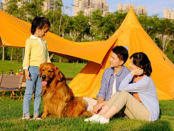Boldog család három és kisállat kutya a parkban — Stock Fotó