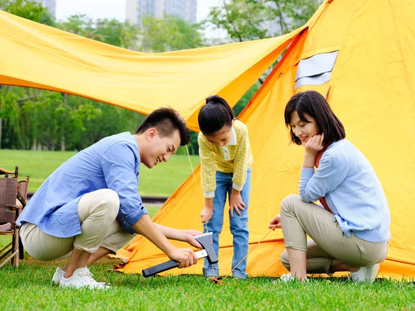 Счастливая семья из трех человек установила палатки на открытом воздухе — стоковое фото