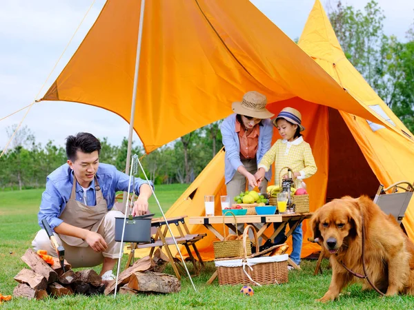 Üç kişilik mutlu bir aile ve açık havada köpek maması. — Stok fotoğraf