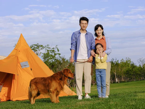 Familia feliz de tres y perro mascota en el parque —  Fotos de Stock