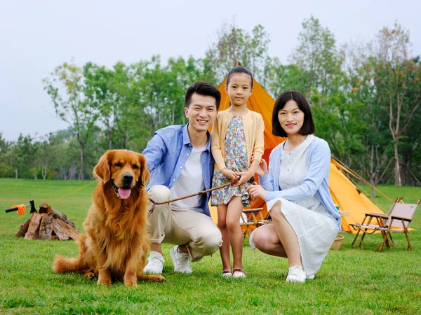 Familia feliz de tres y perro acampando —  Fotos de Stock