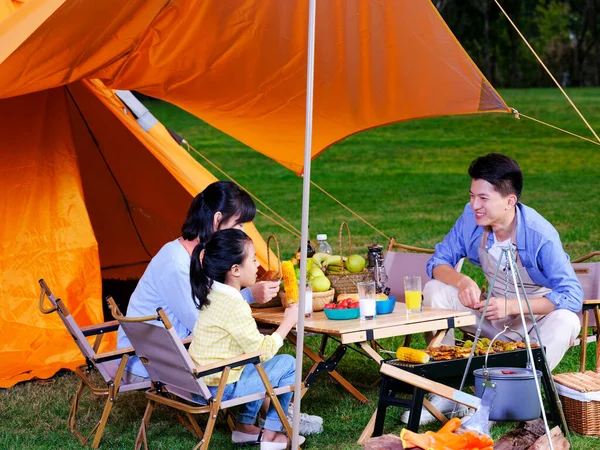 A happy family of three having barbecue in the park — Stock Photo, Image