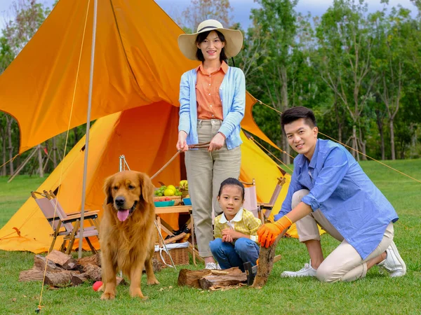 Familia feliz de tres y perro acampando —  Fotos de Stock