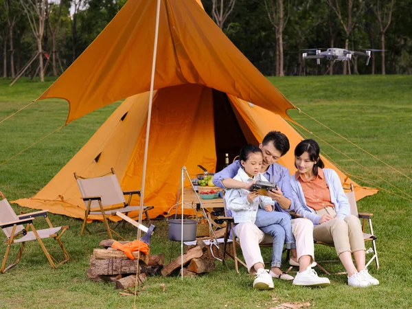 Familia feliz de tres controles UAV en parque —  Fotos de Stock