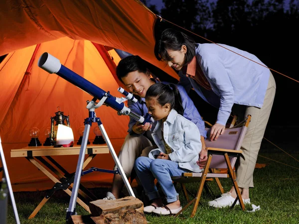 Egy boldog háromtagú család teleszkópokkal a szabadban. — Stock Fotó