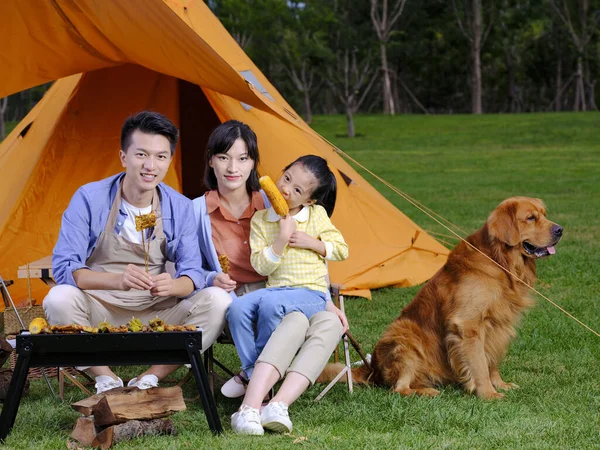 Familia feliz de tres y mascota perro barbacoa en el parque —  Fotos de Stock