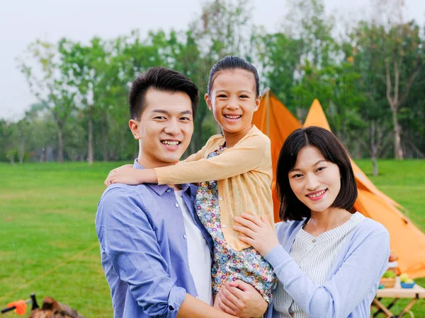 Uma família feliz de três acampar ao ar livre — Fotografia de Stock