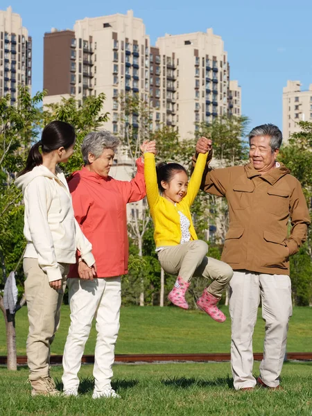 Família feliz de quatro brincando no parque — Fotografia de Stock