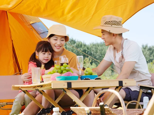 Una familia feliz de tres teniendo un picnic al aire libre —  Fotos de Stock