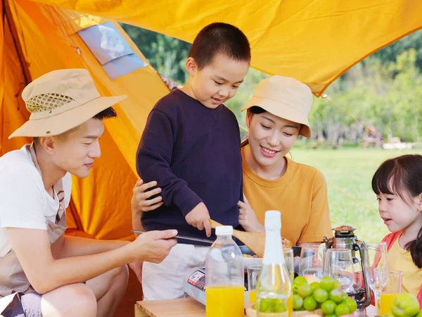 Egy boldog négytagú család piknikezik a szabadban. — Stock Fotó