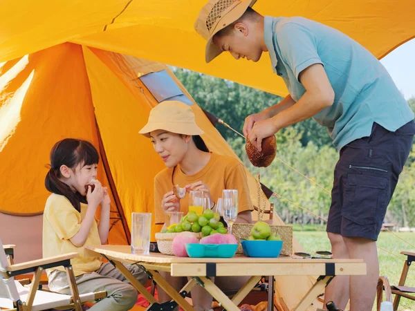 Una familia feliz de tres teniendo un picnic al aire libre —  Fotos de Stock