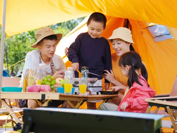 Egy boldog négytagú család piknikezik a szabadban. — Stock Fotó