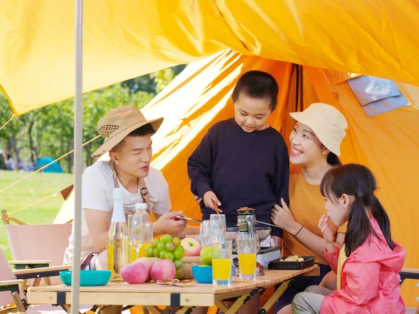 Una famiglia felice di quattro persone che fa un picnic all'aperto — Foto Stock