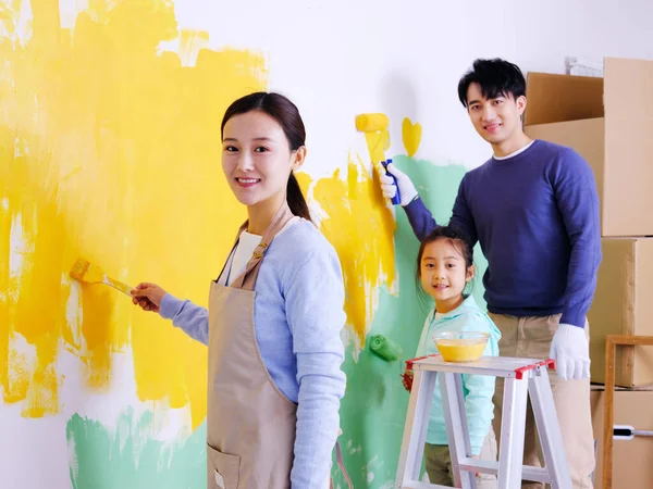 Uma família feliz de três paredes de pintura — Fotografia de Stock